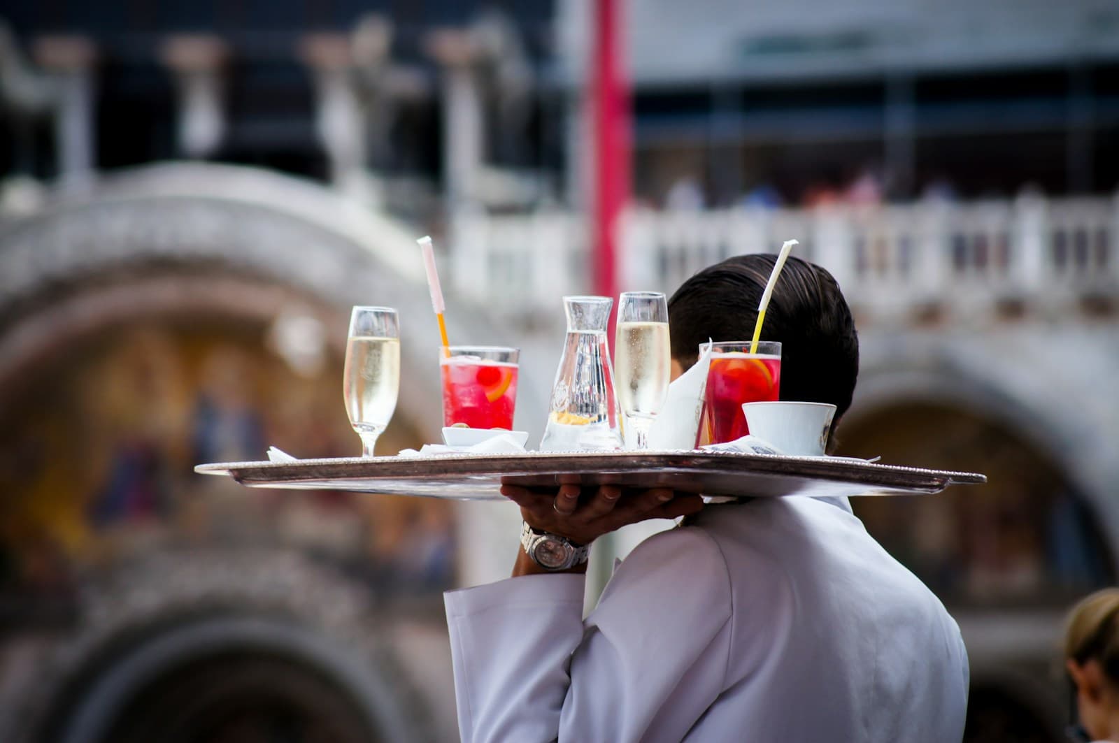 Server carefully plating dishes at a catering station before service